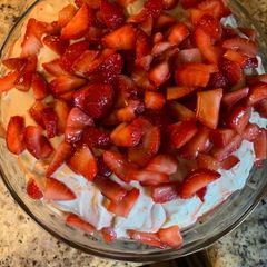 A picture of Strawberry Cake with Mini Chocolate Chips, Cream Cheese Icing and Fresh Strawberries.
