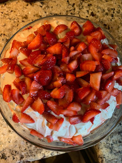 A picture of Strawberry Cake with Mini Chocolate Chips, Cream Cheese Icing and Fresh Strawberries.