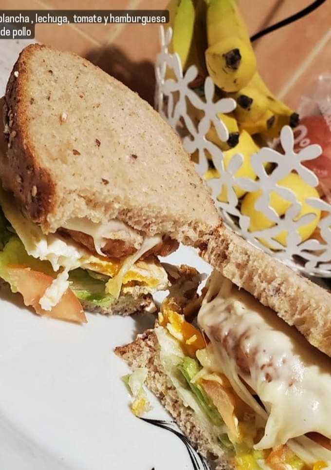 Una foto de Sándwich integral con huevo, lechuga, tomate y hamburguesa 😋