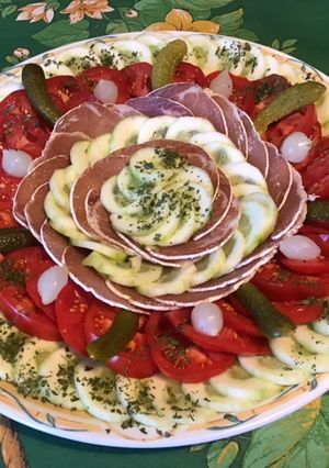 Une photo de Salade de tomates et concombre au lonzo,cornichons et petits oignons