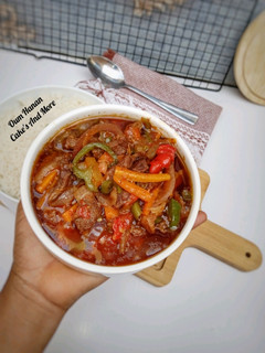 A picture of Shredded beef sauce with veggies.