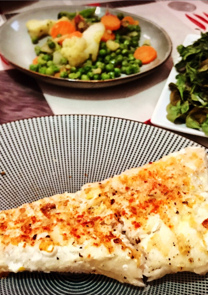 Una foto de Merluza a la parrilla con guarnición de verduras y espinacas crujientes