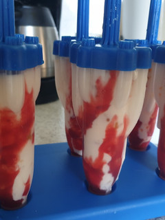 Una foto de Polos de yogurt Griego, mermelada de melocotón y sirope de fresa