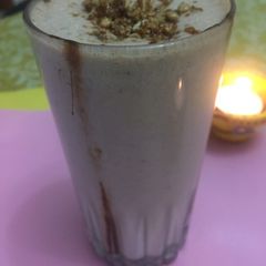 A picture of Oats & Strawberry Milkshake with caramelized sunflower seeds.