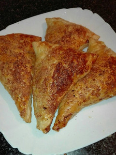 Una foto de Triángulos de hojaldre relleno de nocilla con crocanti de azúcar moreno y almendras molida