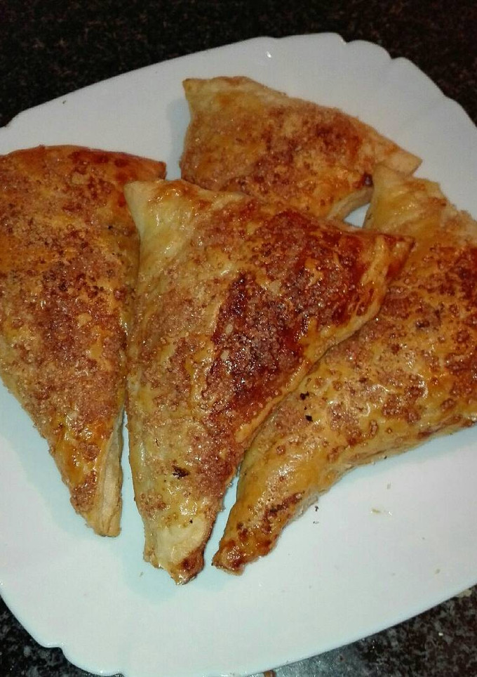 Una foto de Triángulos de hojaldre relleno de nocilla con crocanti de azúcar moreno y almendras molida 
