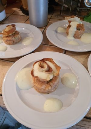 Une photo de Tartare de saumon en corolles de brick, espuma coco curry