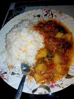 A picture of Tomato,potato spicy curry with rice.