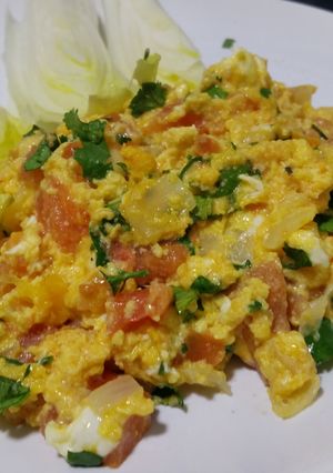 A picture of Herby cheese, egg and tomato scramble.