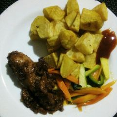 A picture of Diced potatoes, buttered vegetables and barbeque chicken.