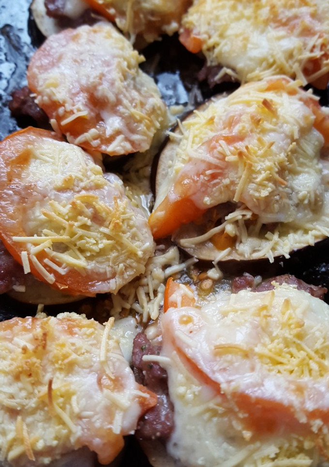 Una foto de Berenjenas en el horno con carne y tomate fresco
