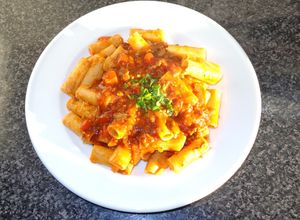 Una foto de Canutos con salsa boloñesa