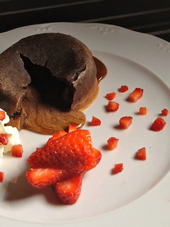 Una foto de Volcán de chocolate con fresas y nata