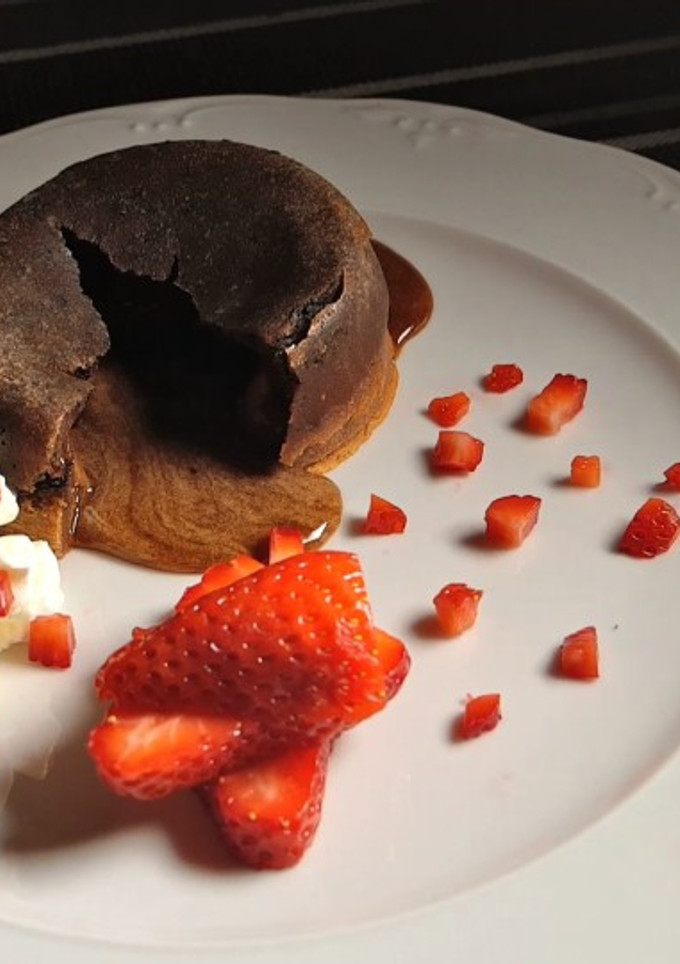 Una foto de Volcán de chocolate con fresas y nata