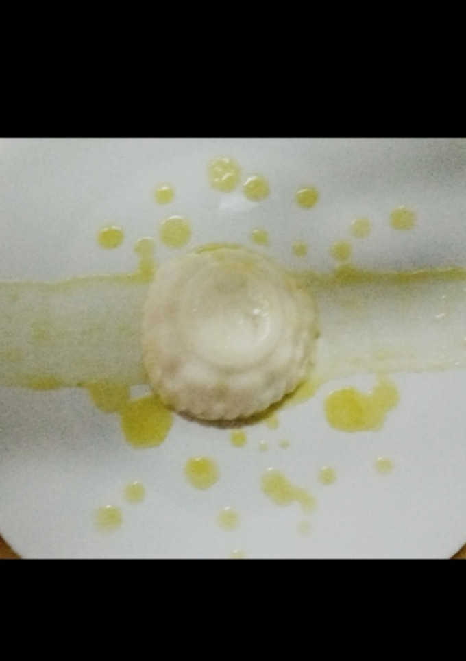 Una foto de Panna cotta de coco con coulis de piña y pimienta rosa