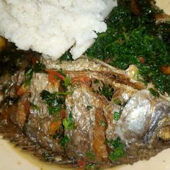 A picture of Fish stew, spinach and ugali.