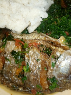 A picture of Fish stew, spinach and ugali.
