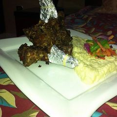 A picture of Fried champ with mashed potatoes and vages.