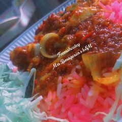 A picture of Pink rice with stew and veggies.