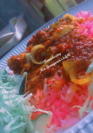 A picture of Pink rice with stew and veggies.