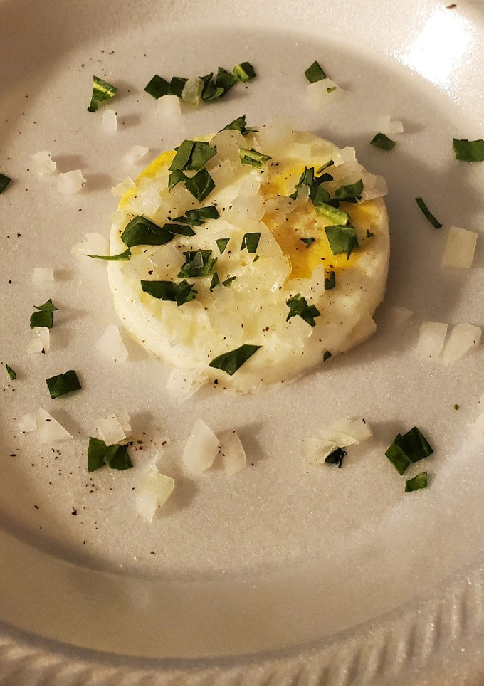A picture of Poached eggs with cut spinach and onions.