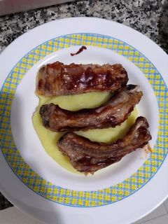 Una foto de Costillas asadas a la barbacoa sobre cama de puré de patata