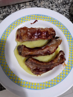 Una foto de Costillas asadas a la barbacoa sobre cama de puré de patata