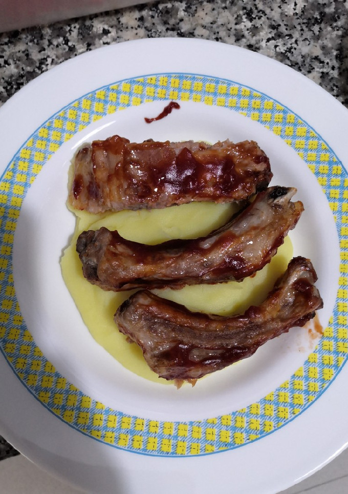 Una foto de Costillas asadas a la barbacoa sobre cama de puré de patata