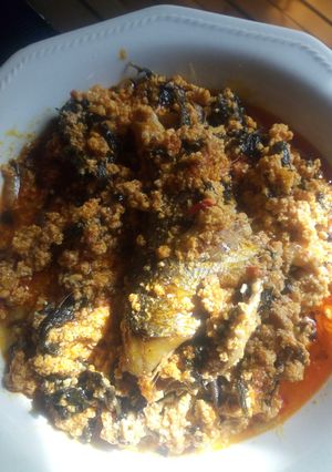 A picture of Egusi soup garnished with bitterleaf.