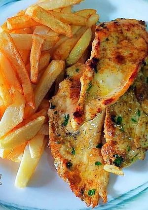 Una foto de Pechuga de pollo al curry amarillo hindú con ajos y perejil