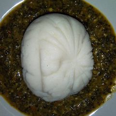 A picture of Powdered rice swallow with spinach and bitter leaf soup.
