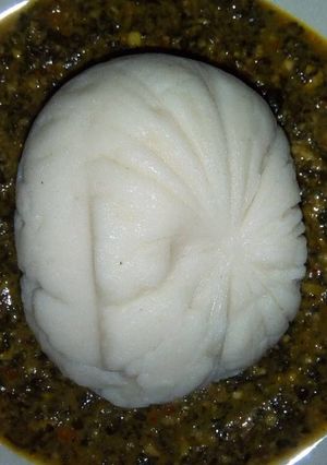 A picture of Powdered rice swallow with spinach and bitter leaf soup.