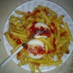 A picture of Boiled eggs served with fries.