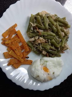 Una foto de Habichuelas salteadas con chips de calabaza y huevo poche