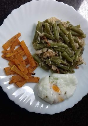 Una foto de Habichuelas salteadas con chips de calabaza y huevo poche