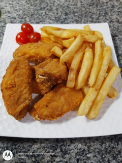 Una foto de Alitas de Pollo a la Romana con Papas Fritas