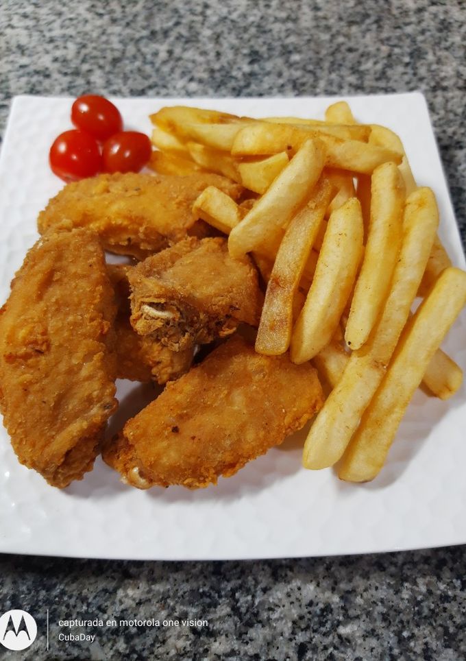 Una foto de Alitas de Pollo a la Romana con Papas Fritas