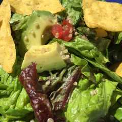 Una foto de Ensalada de quinoa, palta, tomate, lechuga y nachos
