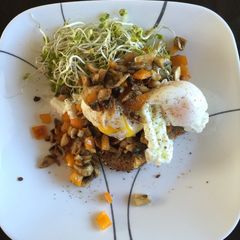 A picture of Poached eggs with veggies and shoots.