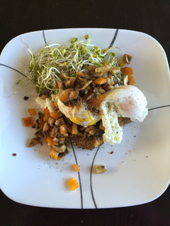 A picture of Poached eggs with veggies and shoots.