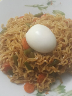 A picture of Indomine with carrots,green pepper and boiled egg.