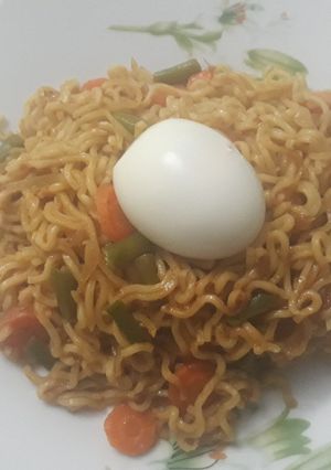 A picture of Indomine with carrots,green pepper and boiled egg.