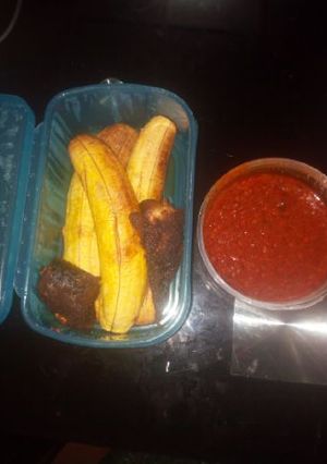 A picture of Roasted plantain with fish and palmoil sauce.