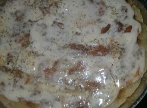 Una foto de Pizza batida con salsa casera a base de comino y azúcar