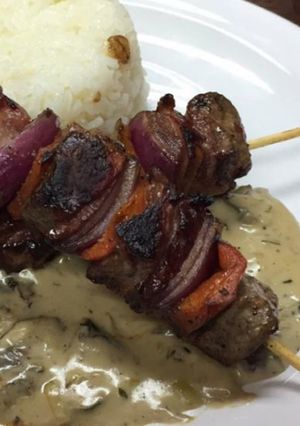 Una foto de Brochetas con salsa de hongos y arroz frito