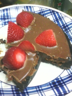 Una foto de Tarta sin hornear, oreo, ganache y frutillas