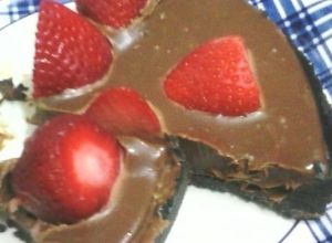 Una foto de Tarta sin hornear, oreo, ganache y frutillas