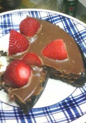 Una foto de Tarta sin hornear, oreo, ganache y frutillas