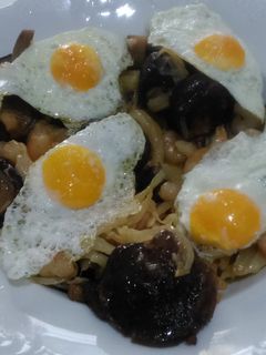 Una foto de Revuelto de shiitake con gambitas y huevo de codorniz