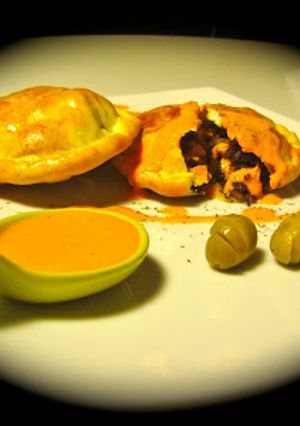 Una foto de Empanadillas de morcilla y pera con salsa de piquillos